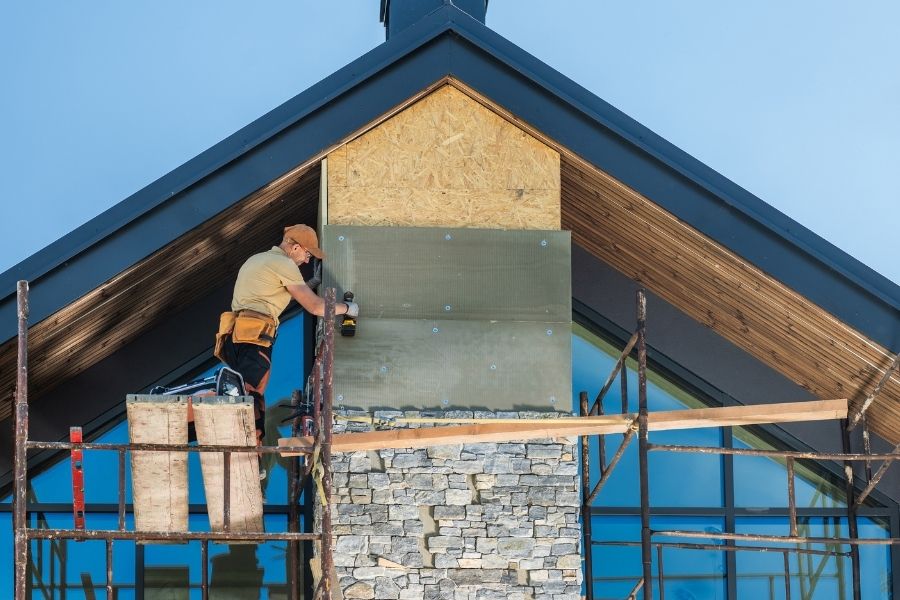 Construction Worker Installing Stone Veneer on a Modern Home